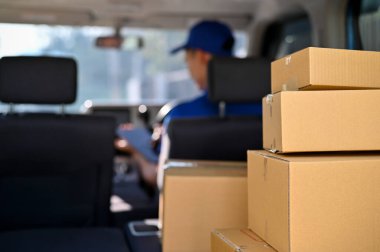 Arka planda teslimatçı adamın olduğu paket kutuları karavanda. paket teslimatı kavramı