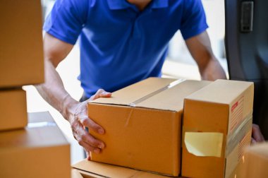 Close up view of delivery man organizing parcels before giving it to customer. parcel delivery service concept clipart