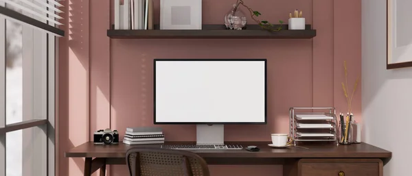 Trendy pink home office interior design with computer white screen mockup and decor on wood table against the pink wall. Girly home working room. 3d render, 3d illustration