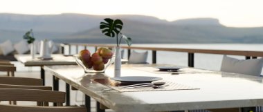 Lüks yemek masası dekorasyonu, rahat koltukları ve güzel Dağ Manzarası olan açık hava restoranı dış tasarımı. 3d görüntüleme, 3d illüstrasyon