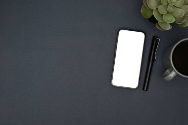 Akıllı telefon beyaz ekran modeli, kalem, kahve fincanı, dekor bitkisi ve mavi arkaplanda metninizi göstermek için kopya alanı. en üstteki görünüm