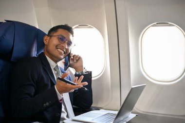 Profesyonel ve başarılı Asyalı işadamı telefonda konuşuyor, yurtdışı iş görüşmesi için seyahat ederken iş görüşmesi yapıyor..