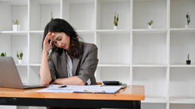 Asyalı bin yıllık iş kadını iş projesinden ve son teslim tarihinden endişe ediyor, patronundan şikayet alıyor, masasında oturuyor..