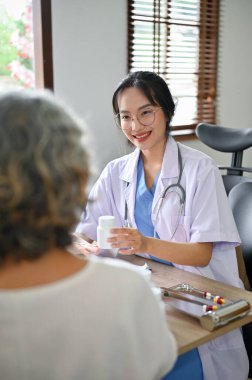 Portre, Yakışıklı ve profesyonel Asyalı kadın doktor hastaya tıp eğitimi veriyor..