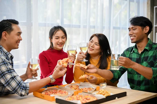 Group of diversity Asian friends enjoy talking, having fun, drinking wine and eating pizza in the party at home. friendship, enjoyment