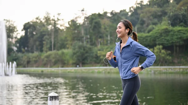 Güzel Bir Parkta Koşarken Kulaklıklarıyla Müzik Dinleyen Aktif Mutlu Bir — Stok fotoğraf