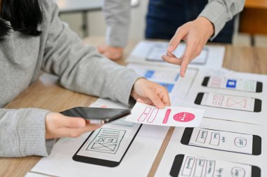 kırpılmış resim, mobil uygulama arayüzü tasarımcılarından oluşan bir ekip toplantıda, uygulamalarını planlıyorlar ve tasarlıyorlar.