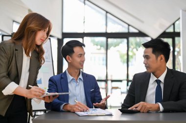 Odaklanmış ve zeki Asyalı iş adamı iş ortağıyla toplantıda konuşuyor..