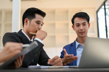 İki konsantre ve zeki Asyalı iş adamı projeleri üzerinde konuşuyor, planlıyor ve birlikte çalışıyorlar..