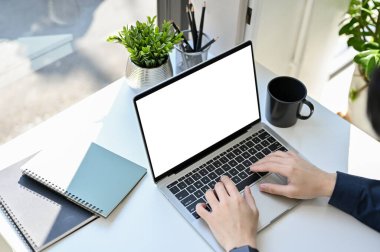 Üst görünüm, profesyonel işadamı ya da erkek ofis çalışanı dizüstü bilgisayar kullanıyor, ofis masasında klavyesine klavye yazıyor. dizüstü bilgisayar beyaz ekran modeli.