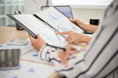 cropped and close-up shot, Group of professional businesspeople or financial analysts checking a financial report together in the meeting.