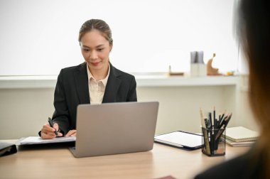 Gorgeous and professional millennial Asian businesswoman or female HR recruiter interviewing a candidate in the meeting room. job recruitment and interview concept