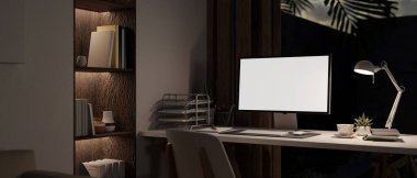 Modern contemporary home working room at night with PC desktop computer mockup and accessories on table, built-in shelves with home decor. 3d render, 3d illustration