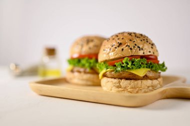 Close-up image of a tasty beef burgers on wooden tray on white background. fast food concept