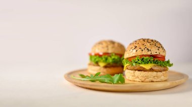 Tasty delicious beef burgers on wooden plate on white background with empty space. close-up image