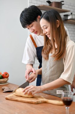 Happy Asian couple making brunch in the kitchen together, having romantic time while cooking, preparing dinner for their dinner night. in love, boyfriend and girlfriend