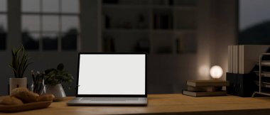 Geceleri modern karanlık ofis odasındaki ahşap masa üstünde dizüstü bilgisayar ve aksesuarlar. çalışma alanı yakın çekim görüntüsü. 3d görüntüleme, 3d illüstrasyon