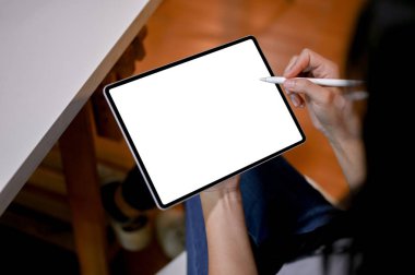Close-up, back view image of an Asian woman using her portable digital tablet, designing her graphic work on tablet. tablet white screen mockup