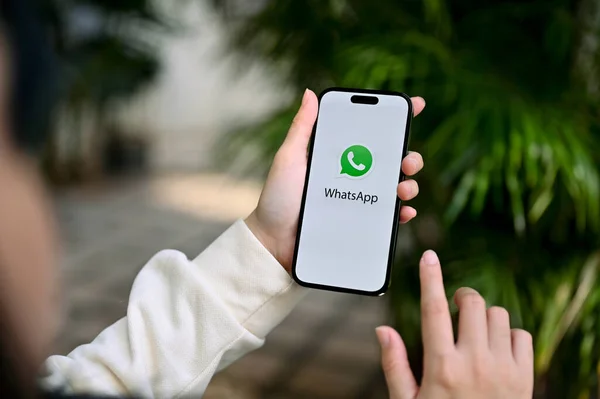 泰国清迈 2023年2月13日 一位女性使用Whatsapp应用程序与朋友聊天的特写图片 她在屏幕上举着一个带有Whatsapp标志的Iphone — 图库照片