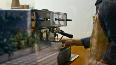 Male barista or bartender in the coffee shop making cappuccino with espresso machine. small business concept. cropped image