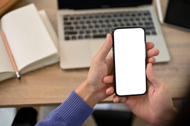Close-up image of a male college student using his smartphone while doing homework at home. smartphone white screen mockup