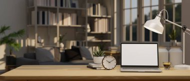 Workspace with laptop white screen mockup, table lamp, alarm clock, and decor on wood tabletop over blurred background of a contemporary home living room. 3d render, 3d illustration