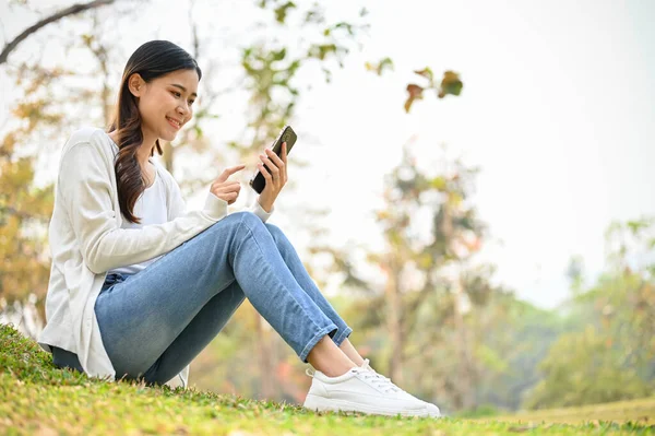 Atractiva Joven Asiática Con Ropa Cómoda Usando Teléfono Inteligente Mientras — Foto de Stock