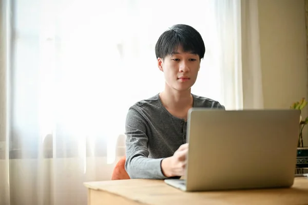 Geconcentreerde Jonge Aziatische Man Causale Kleding Met Behulp Van Laptop — Stockfoto