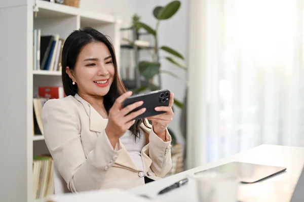 Atraktivní Šťastný Tisíciletá Asijská Podnikatelka Sledování Videa Svém Smartphonu Při — Stock fotografie