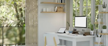 Masada PC masaüstü bilgisayarı ve tablet boş ekran maketi, kaktüs rafı, sandalye ve dekor ile modern beyaz ev iç mimarisi tasarımı. 3d görüntüleme, 3d illüstrasyon