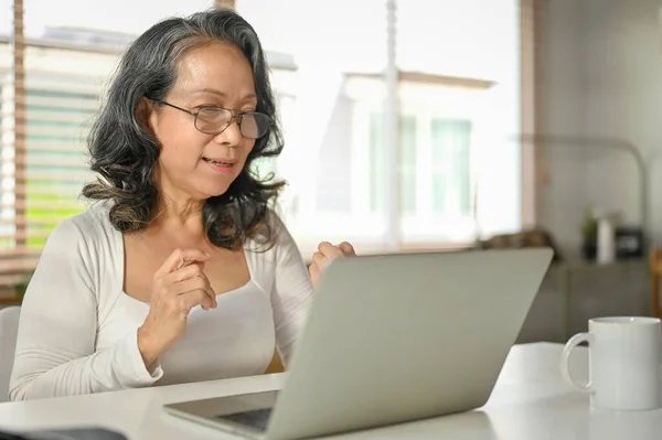 Eine Glückliche Asiatische Rentnerin Benutzt Ihren Laptop Ihrem Arbeitsplatz Hause — Stockfoto