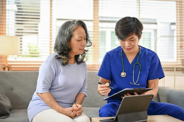 一位快乐而轻松的60岁的亚洲退休妇女与医院的一位医生有一个医疗预约 — 图库照片
