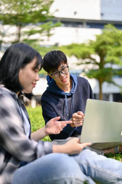 一个聪明的年轻的亚洲大学生 给他的女朋友教数学 或者一起在大学公园里做功课 — 图库照片