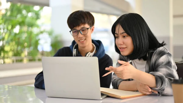 两名聪明而快乐的年轻亚洲大学生正在校园里准备考试或一起用笔记本电脑做功课 — 图库照片