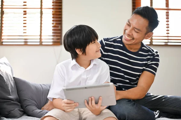 즐겁고 아시아인 아버지는 온라인으로 아이들의 게임을 즐기거나 거실에 타블렛에서 아이들의 — 스톡 사진