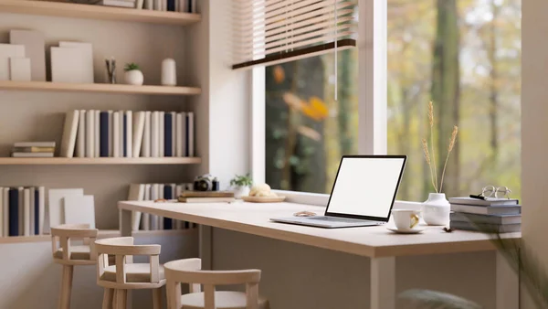 Stock image Minimal comfortable workspace with laptop white screen mockup on wood table against the window, stools, and large bookshelves. side view. 3d render, 3d illustration