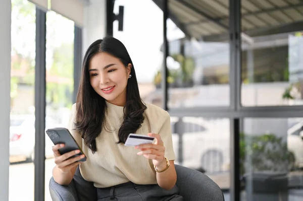 Aantrekkelijke Duizendjarige Aziatische Vrouw Met Haar Smartphone Creditcard Met Behulp — Stockfoto