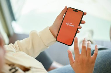 Chiang Mai, Tayland - 31 Mart 2023: Akıllı telefonunda Payonez uygulaması kullanan bir kadın. Ekranda Payonez logo uygulaması olan iPhone 