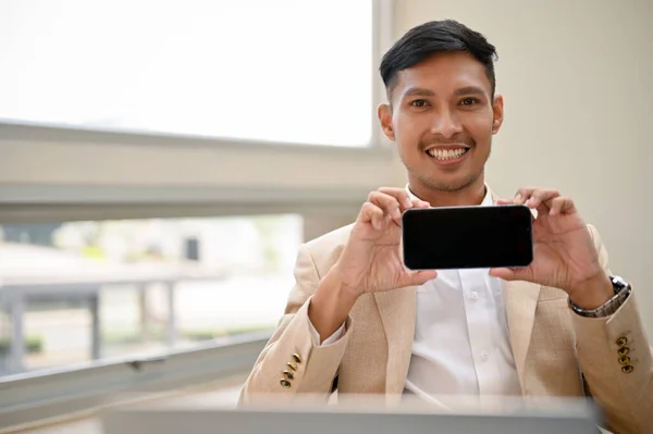 面带微笑的千年亚洲商人 将智能手机放在水平位置上 显示智能手机黑屏 — 图库照片