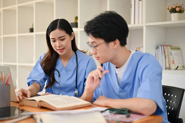 有魅力的年轻亚洲女医科学生和她的朋友一起在图书馆学习和准备考试 — 图库照片