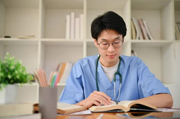 Έξυπνος Νεαρός Ασιάτης Φοιτητής Ιατρικής Στολή Επικεντρώνεται Στην Ανάγνωση Ενός — Φωτογραφία Αρχείου