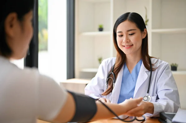 一名专业的亚洲女医生在检查室用监视器检查病人的脉搏 心率和血压 — 图库照片