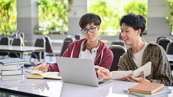 两名英俊而快乐的亚洲年轻大学生正在网上研究信息 看笔记本电脑屏幕 一起学习功课 — 图库照片