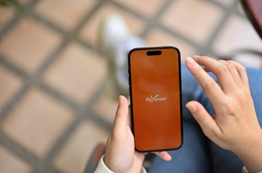 Chiang Mai, Tayland - 18 Nisan 2023: Telefonunda Payonez uygulaması kullanan bir kadın. Ekranda Payonez logosu olan iPhone. 
