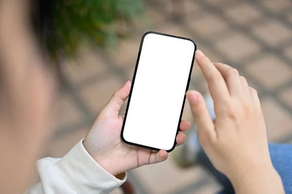 一个亚洲女人在自家后院放松的时候用手机的特写镜头 智能手机白屏模型 — 图库照片