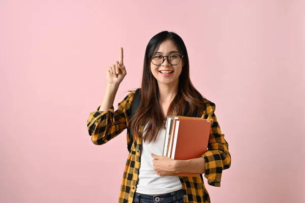 Mosolygó Pozitív Fiatal Ázsiai Egyetemista Lány Tankönyveivel Üres Helyre Mutat — Stock Fotó