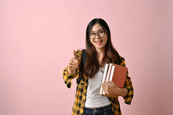 Vidám Fiatal Ázsiai Egyetemista Lány Tankönyveivel Gesztusokat Mutat Miközben Elszigetelt — Stock Fotó