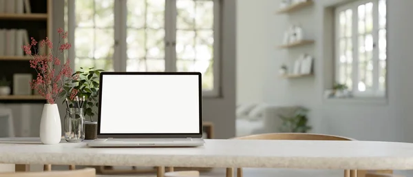 stock image Home workspace with laptop white screen mockup, stationery and decor plants on a dining table in minimal white dining room. close-up image. 3d render, 3d illustration