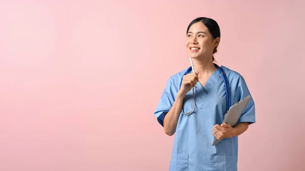 Νεαρή Όμορφη Γυναίκα Γιατρός Κρατώντας Δισκίο Ενώ Στέκεται Ροζ Απομονωμένο — Φωτογραφία Αρχείου