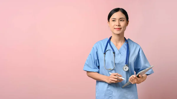 Junge Schöne Ärztin Hält Tablette Stehen Auf Rosa Isolierten Hintergrund — Stockfoto